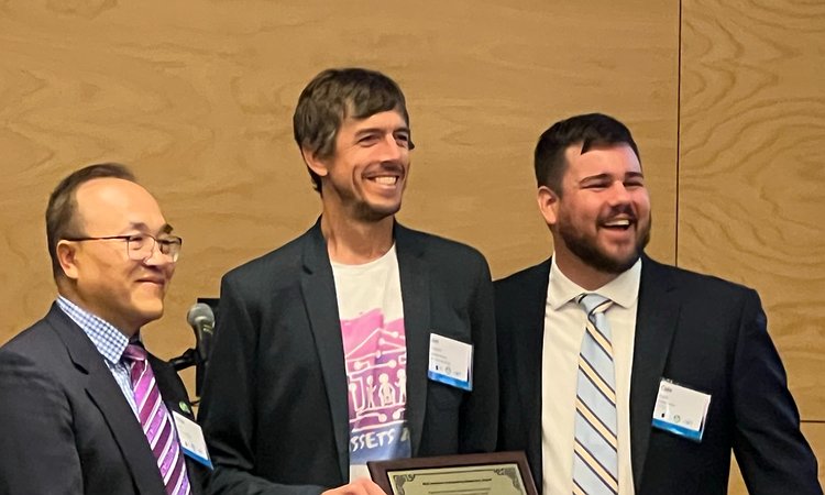 PacTrans Director Yinhai Wang and Assistant Director Cole Kopca giving Jon Froehlich the PacTrans award plaque